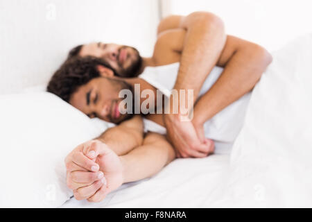 Gay couple sleeping together on bed Stock Photo