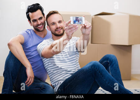 Gay couple taking selfie in their new home Stock Photo
