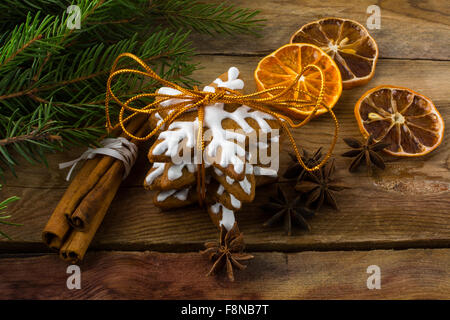 Christmas gingerbread, cookies, cinnamon, anise, fruit slices and fir branches on a wooden background Stock Photo