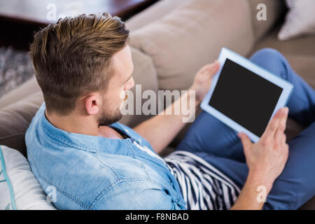 Casual man using tablet on sofa Stock Photo