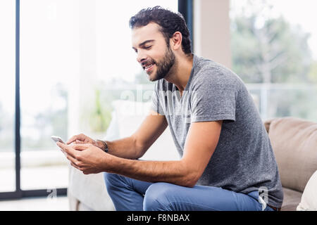 Handsome smiling man using smartphone Stock Photo