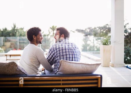 Happy couple sitting on sofa Stock Photo