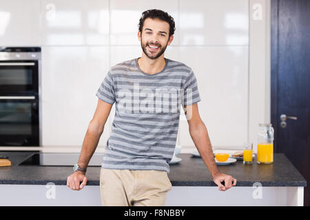 Handsome man leaning against counter Stock Photo