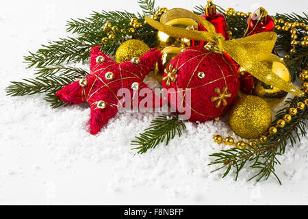 Christmas decoration red and golden balls, star, fir branches in snow on a white background