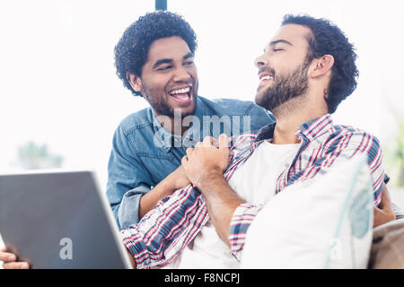 Happy gay couple using laptop Stock Photo