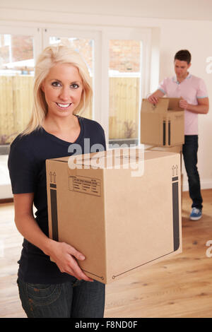 Young Couple Unpacking Boxes In New Home Stock Photo