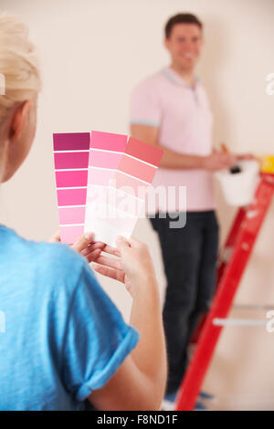 Young Couple Looking At Paint Swatches In New Home Stock Photo
