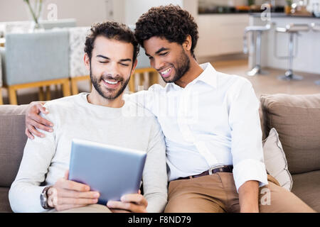 Happy gay couple using tablet Stock Photo