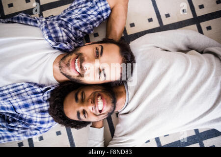 Happy gay couple laying on floor Stock Photo