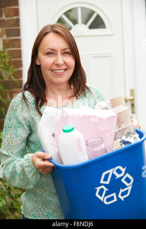 Middle Aged Woman Carrying Recycling Bin Stock Photo