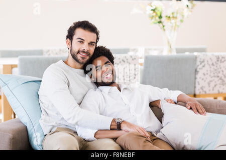Happy gay couple relaxing on sofa Stock Photo