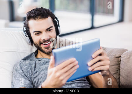 Handsome man using tablet and headphones Stock Photo