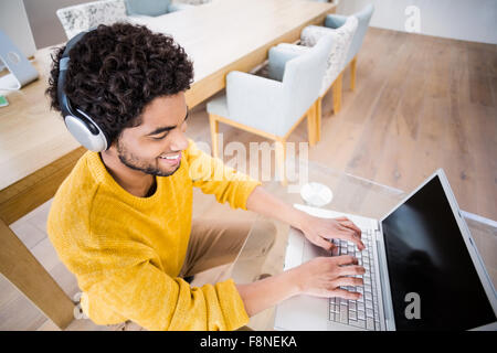 Happy man using headphones and laptop Stock Photo