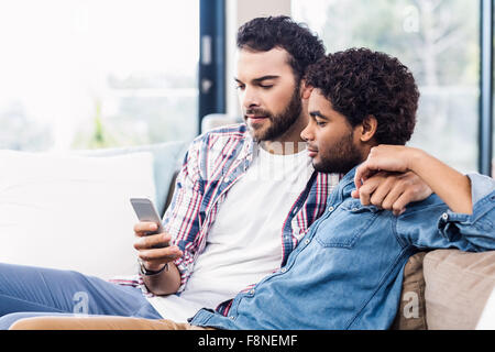 Happy gay couple using smartphone Stock Photo