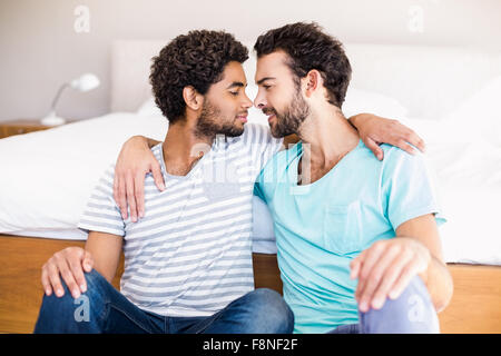 Happy gay couple sitting on the floor Stock Photo