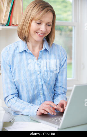 Woman Using Computer In Home Office Stock Photo