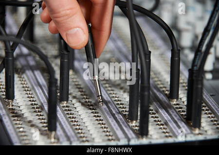 Hand Plugging Cable Into Recording Studio Patch Panel Stock Photo