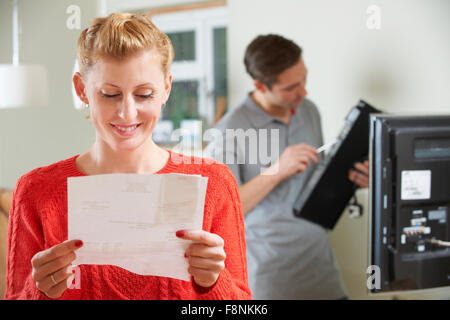 Happy Woman Looking At Bill For TV Installation Stock Photo
