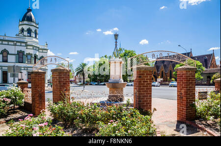 Australia, New South Wales, Forbes, entrance to Victoria Garden with  historic Town Hall and Saint John's Anglican Church. Stock Photo