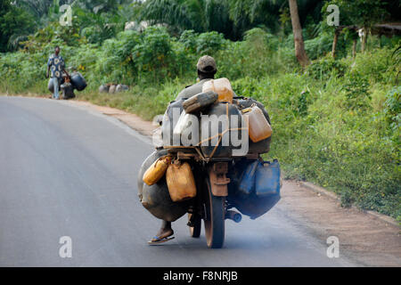 Man on motorcycle transporting containers of gas (petrol, benzine), Benin Stock Photo