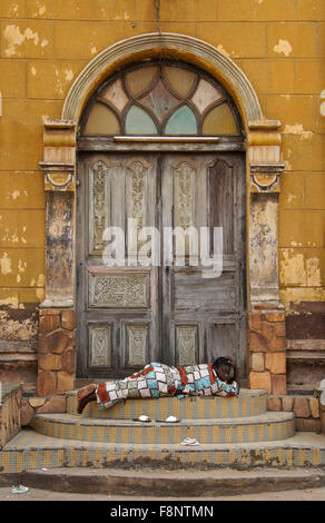 Woman lying in front of ornate doorway of Grand Central Mosque, Porto Novo, Benin Stock Photo