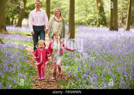 Family Walking Through Bluebell Woods Together Stock Photo