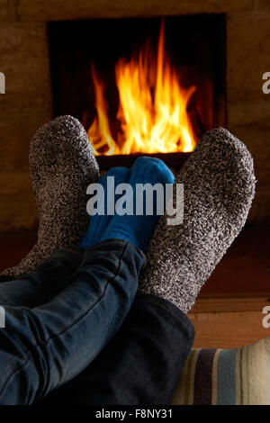 Father And Child Warming Feet By Fire Stock Photo