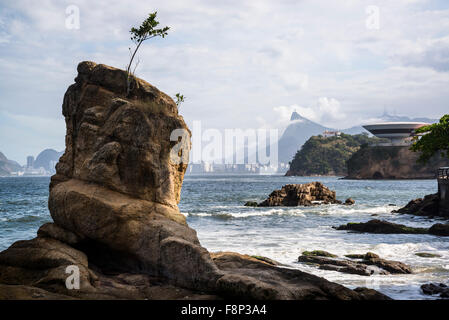 Sea rocks  and view of Rio mountains and Niteroi Contemporary Art Museum, Niteroi, Rio de Janeiro, Brazil Stock Photo