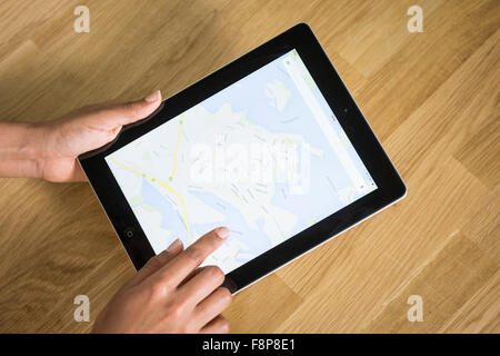 A young mixed-race woman using a mapping app on a tablet Stock Photo