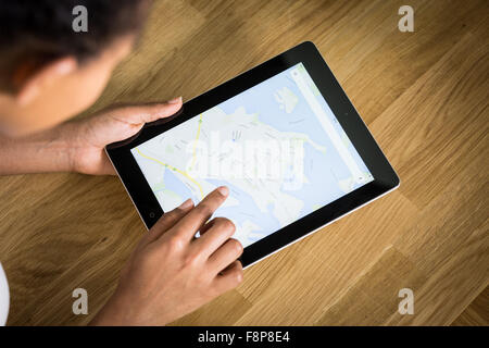 A young mixed-race woman using a mapping app on a tablet Stock Photo