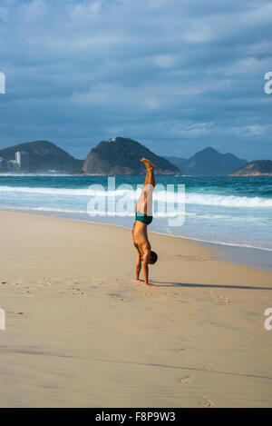 Man doing a handstand, Copacabana Beach, Rio de Janeiro, Brazil Stock Photo