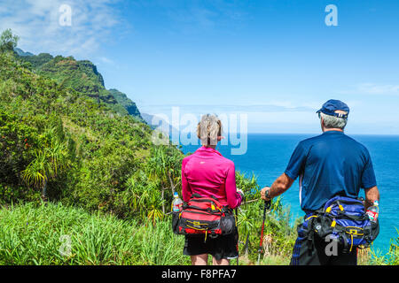 Hikers on the Kalalau Trail enjoy view of the Na Pali Coast on Kauai Stock Photo