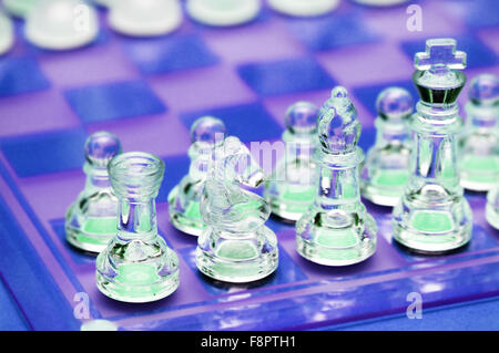 Various chess figures on  the glass chessboard Stock Photo