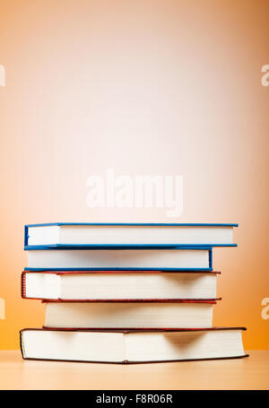 Stack of text books against gradient background Stock Photo