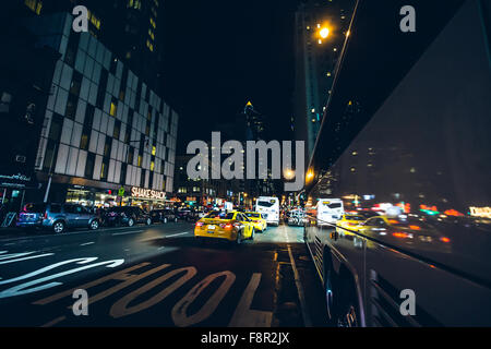 New York City - September 15: Manhattan night view traffic bus reflecting advertisements  8th ave, 15 September 2015. Stock Photo