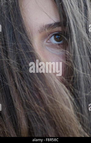 Sad teenage girl hair covering face outdoors Stock Photo