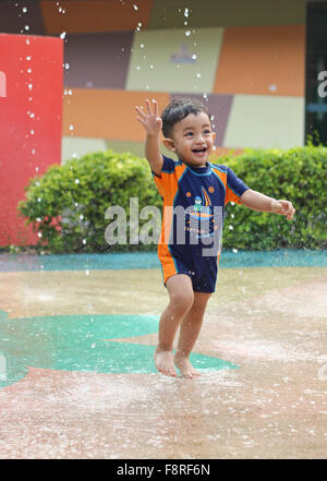 Boy playing in water fountain, Jakarta, Indonesia Stock Photo