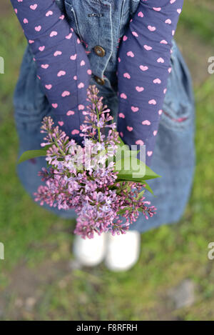 Girl holding bouquet of lilac flowers Stock Photo