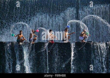 Five children splashing water, Tukad Unda Dam, Bali, Indonesia Stock Photo