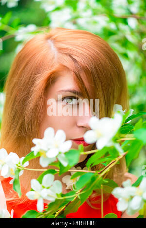 face of a beautiful girl and a blossoming branch of jasmine Stock Photo