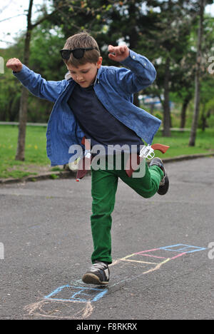 Boy playing hopscotch on the street Stock Photo