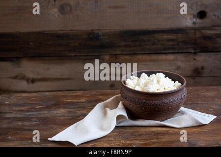 Culinary cottage cheese in a clay bowl on dark wooden table Stock Photo