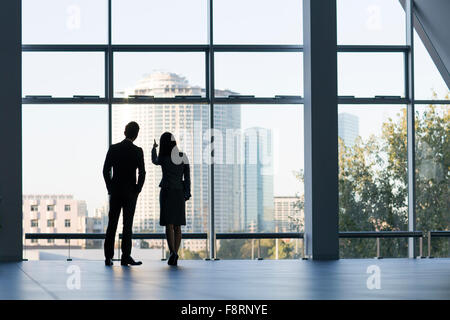 Business person looking through window Stock Photo