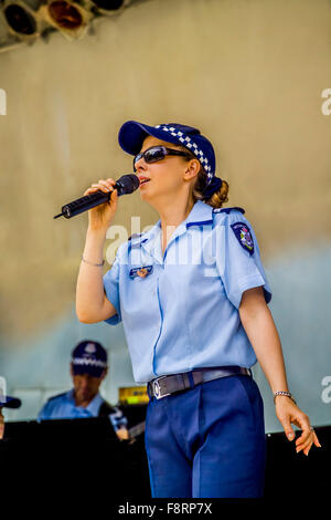 Lead singer female police officer performs in uniform with her Victoria Police colleagues Federation Square, Melbourne Australia Stock Photo