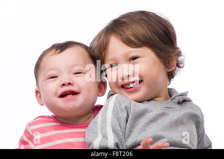 A portrait of a cute and loving brother and sister on a white background. Stock Photo