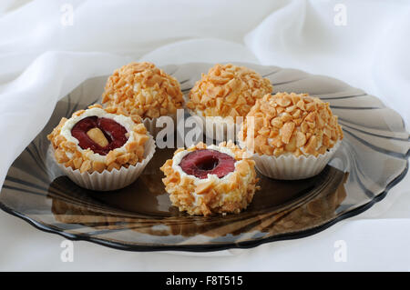 Cheese balls stuffed with cherries in peanuts Stock Photo