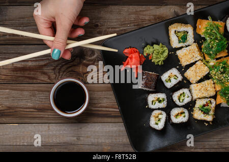 Sushi. Hand with chopsticks Stock Photo