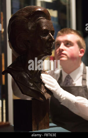 London, UK. 11 December 2015. A Christie's employee looks at a portrait bust of Baroness Thatcher by Neil Simmons. Est. GBP 700-1000. Mrs Thatcher: Property from the Collection of The Right Honourable The Baroness Thatcher of Kesteven, LG, OM, FRS, the former British Prime Minister Margaret Thatcher will be auctioned at Christie's inLondon. 419 historic and personal lots will be offered in across two landmark sales on 15 December and 16 December (online sale). Stock Photo