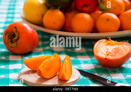 khaki fruit slices on a table Stock Photo