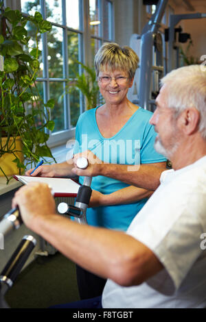 Man in gym using a rowing machine Stock Photo